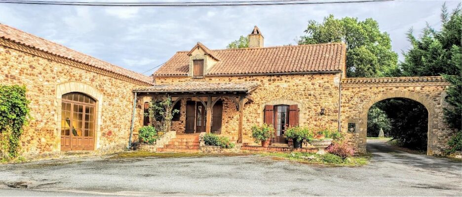 Charming rustic stone house with a tiled roof and wooden shutters.