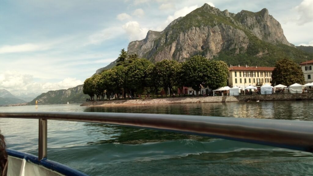 A scenic lakeside view with mountains and trees reflecting in calm water.