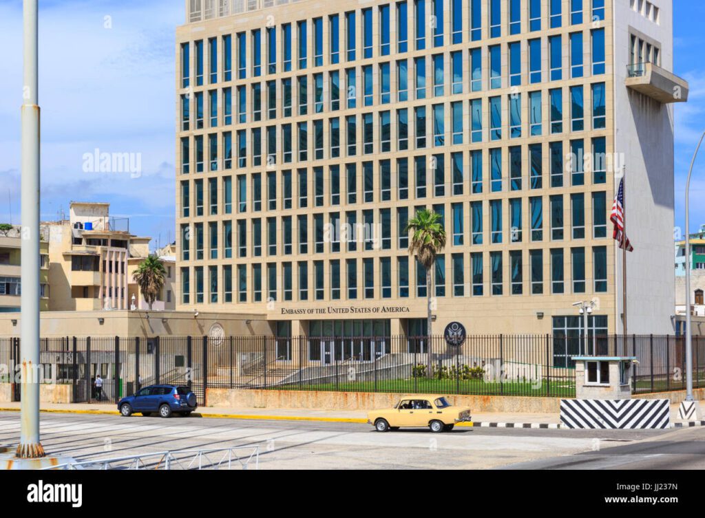 Modern office building with a grid facade and palm trees in front.