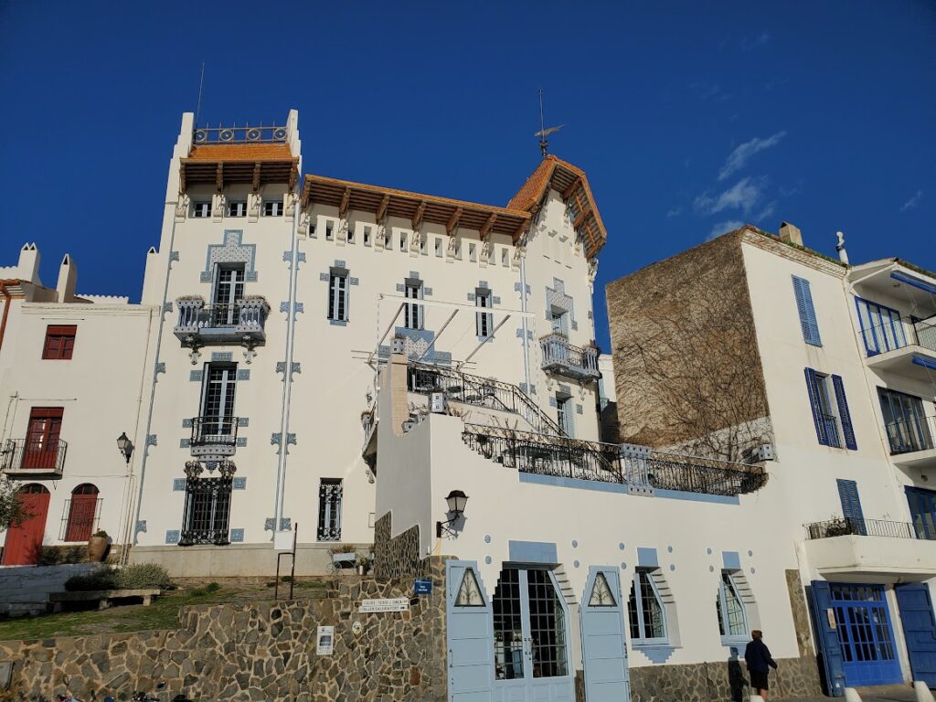 A historic white building with ornate details under a clear blue sky.