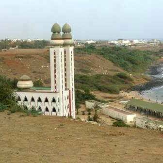 A mosque by the coastline with a scenic view.