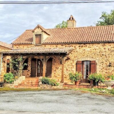 Charming rustic stone house with a tiled roof and wooden shutters.