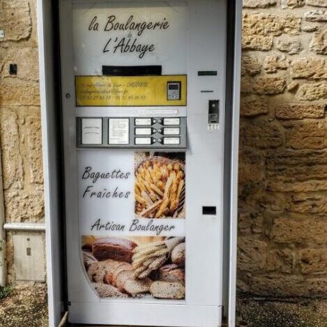 Vending machine selling fresh baguettes in a rustic setting.