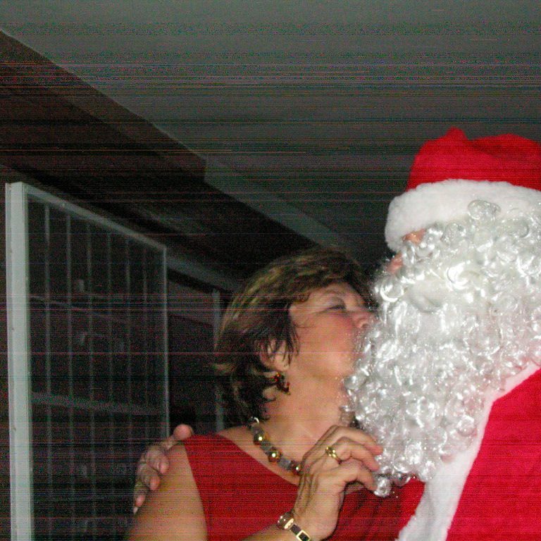 Woman sharing a moment with Santa Claus indoors.