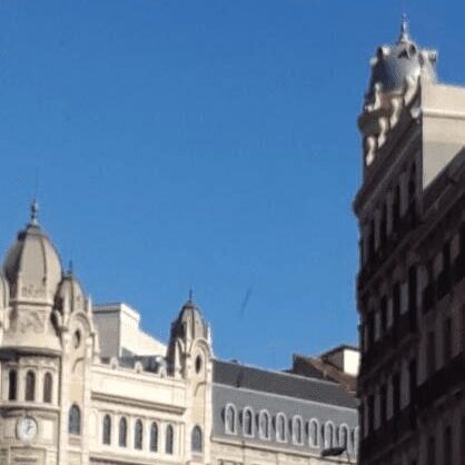 Historic buildings under a clear blue sky in an urban setting.